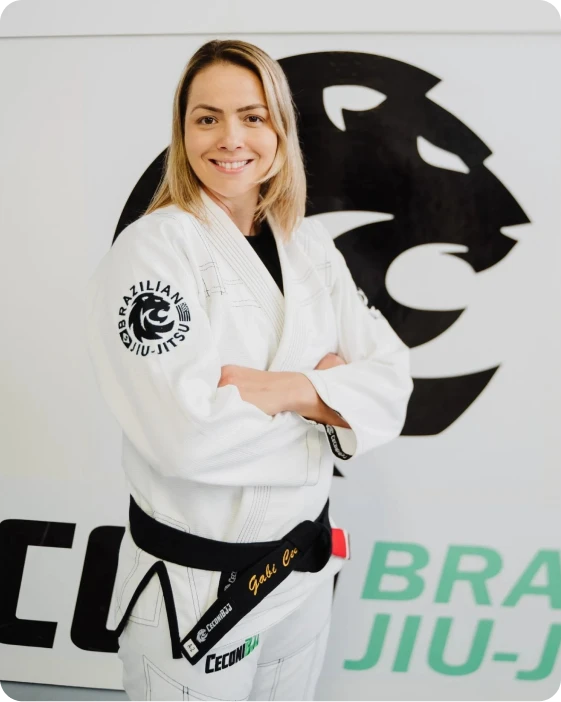 Portrait of Gabriela Rosso Ceconi in front of the Ceconi academy lion emblem. Gabriela Rosso Ceconi wearing a white gi and black belt