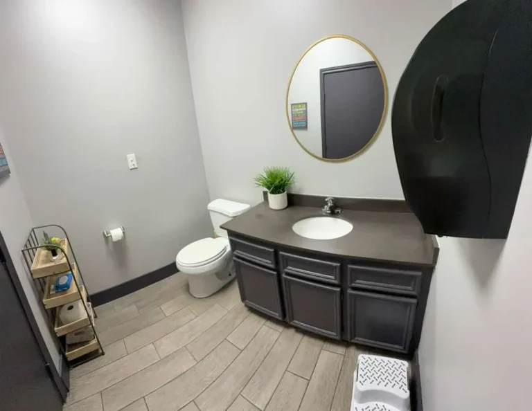 Bathroom amenities at Ceconi BJJ Cypress for students before and after training. Academy bathroom with a sink, mirror and changing area