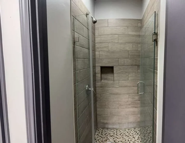 Academy shower available to students after Brazilian Jiu-Jitsu classes. Tiled shower with a glass door at the Ceconi academy